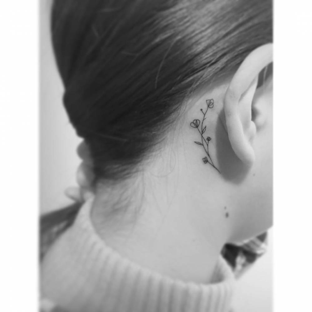 Fine line style flowers tattooed behind the ear.