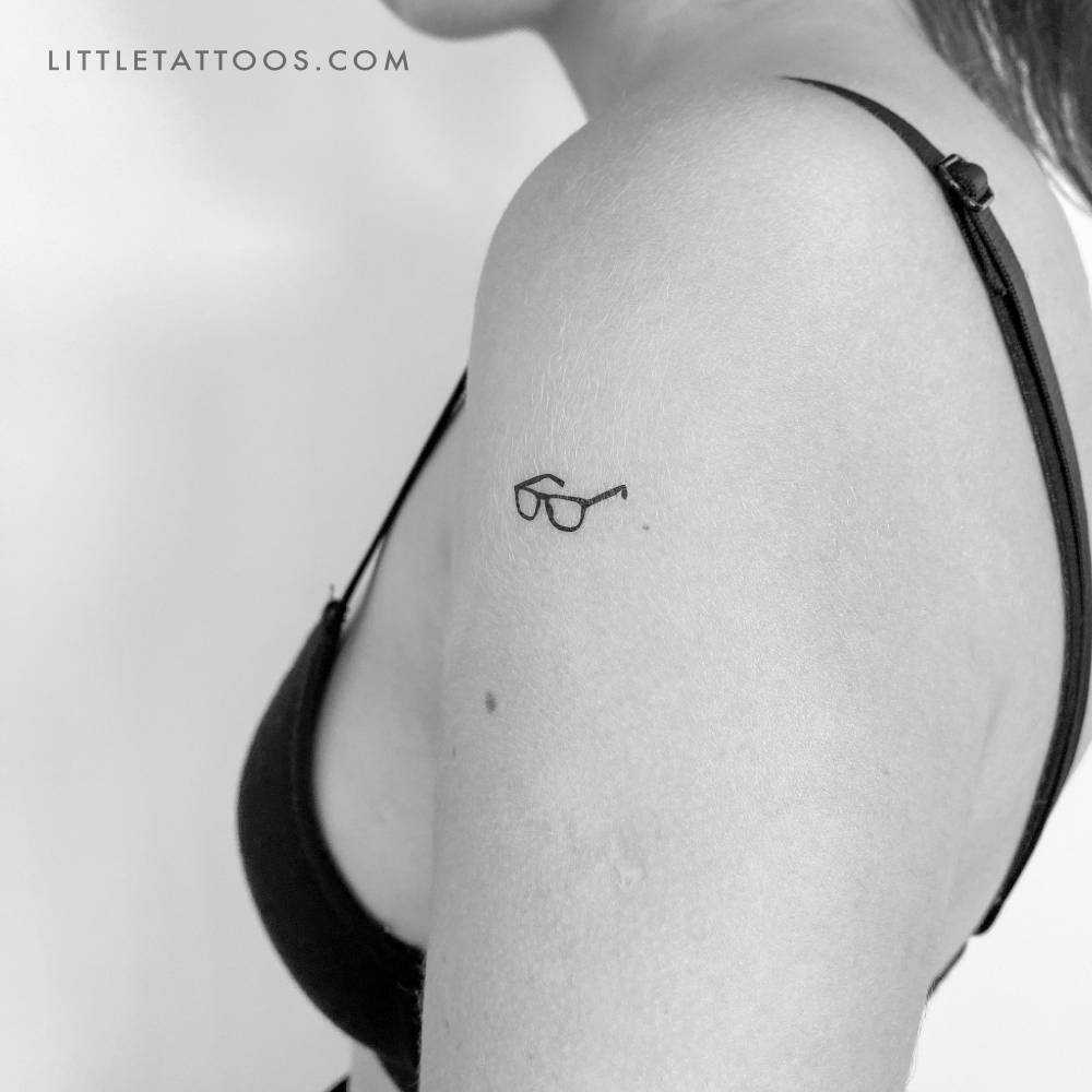 Minimalist style eyeglasses temporary tattoo located on the upper arm.