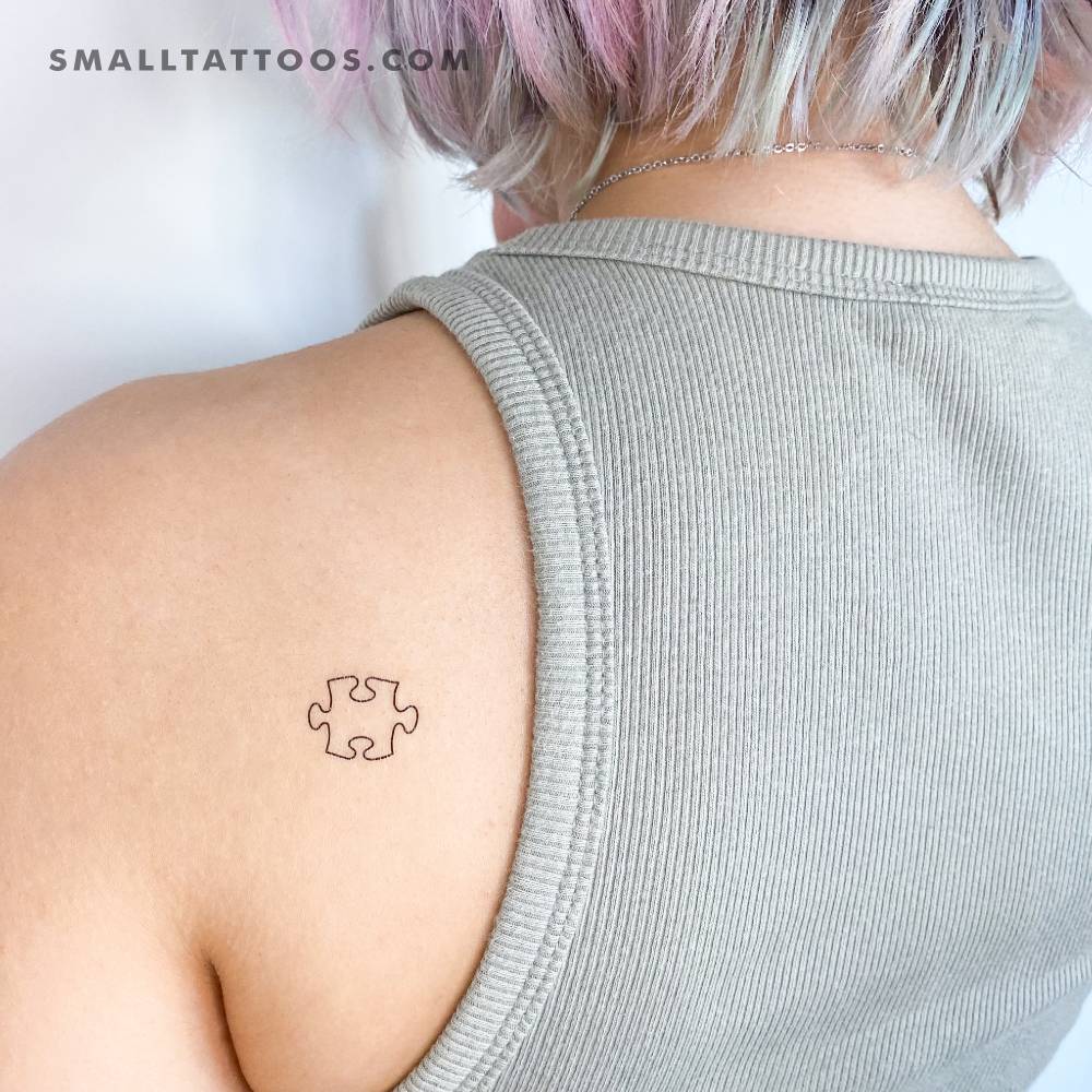 Puzzle piece temporary tattoo located on the shoulder blade.