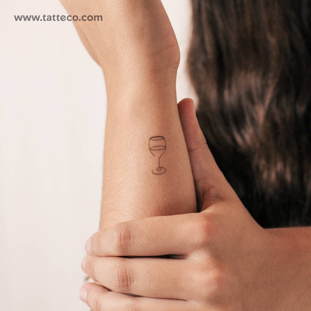 Fine line wine glass semi-permanent tattoo located on the wrist.