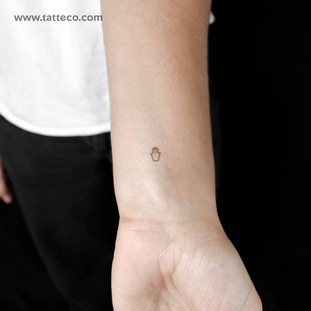 Tiny minimalist hamsa semi-permanent tattoo.