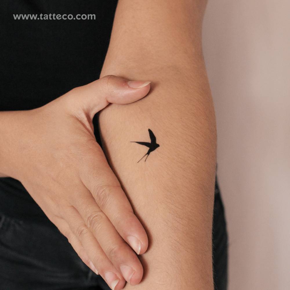 Black swallow semi-permanent tattoo located on the inner forearm.