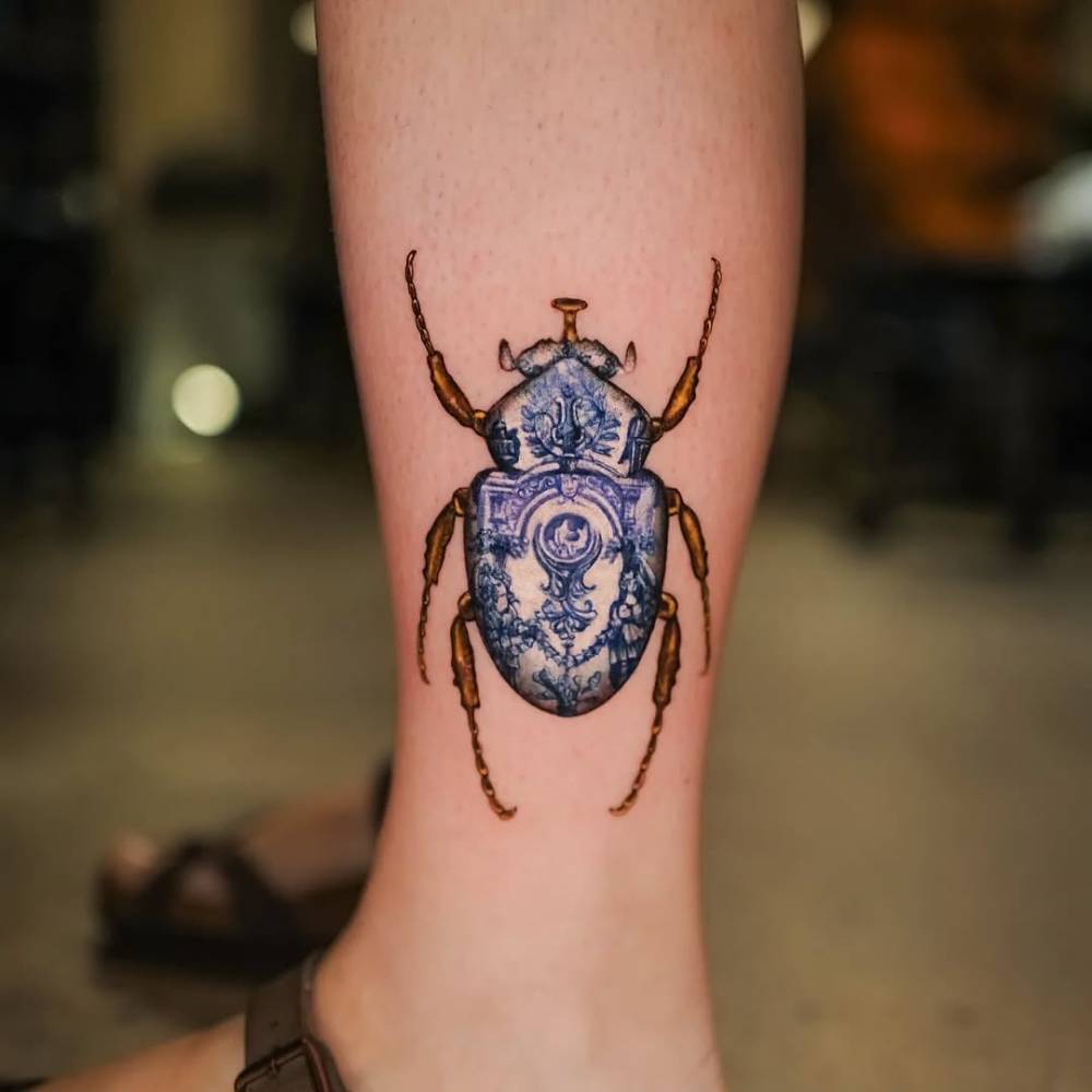 Delftware beetle tattoo located on the shin.