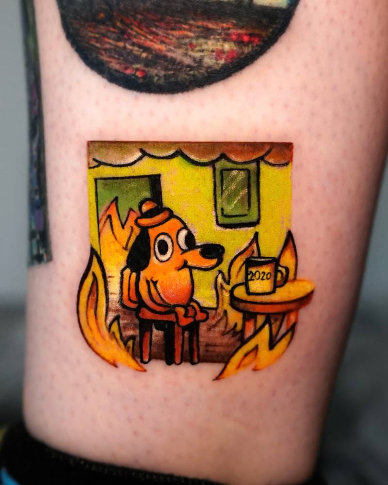 "This is fine" meme tattooed on the ankle, cartoon style.
