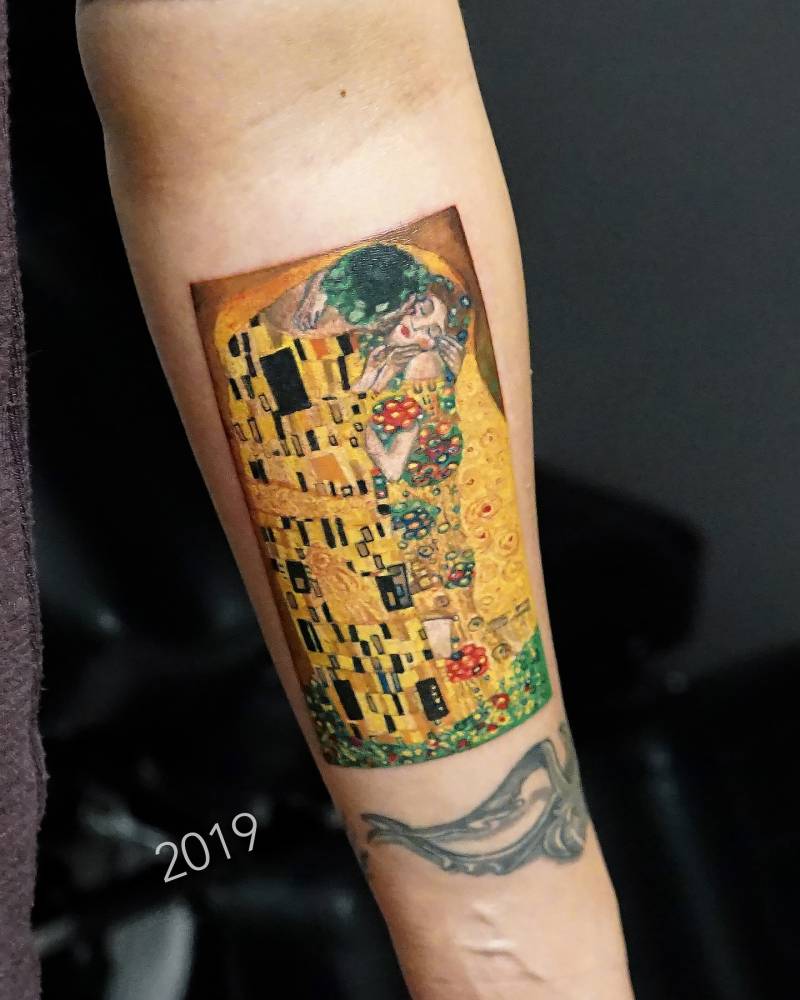 'The Kiss' tattoo located on the inner forearm, contemporary style.