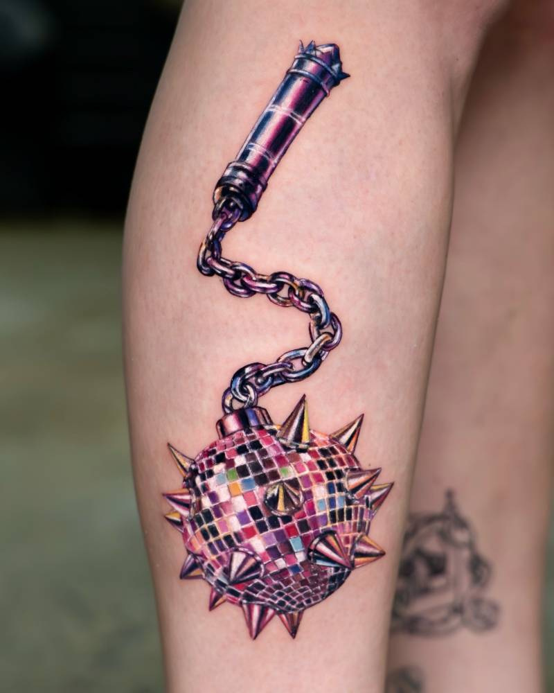 Disco ball medieval flail tattoo located on the shin, realistic style.