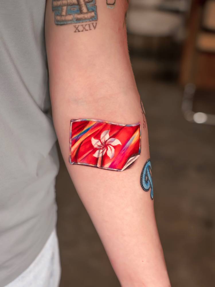 Hong Kong flag sticker tattooed on the inner forearm.
