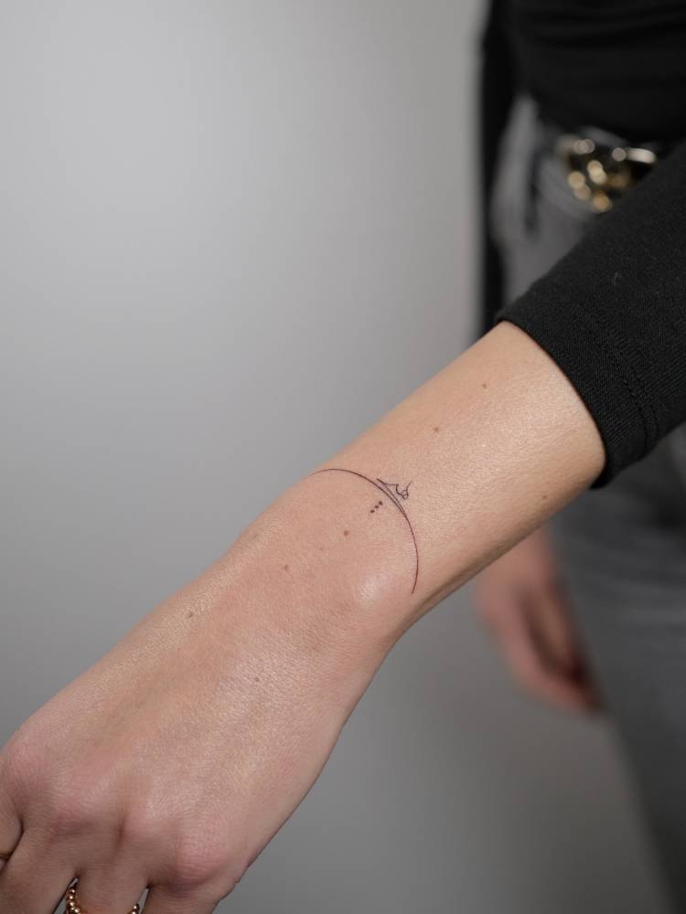 Arabic lettering tattoo located on the wrist.