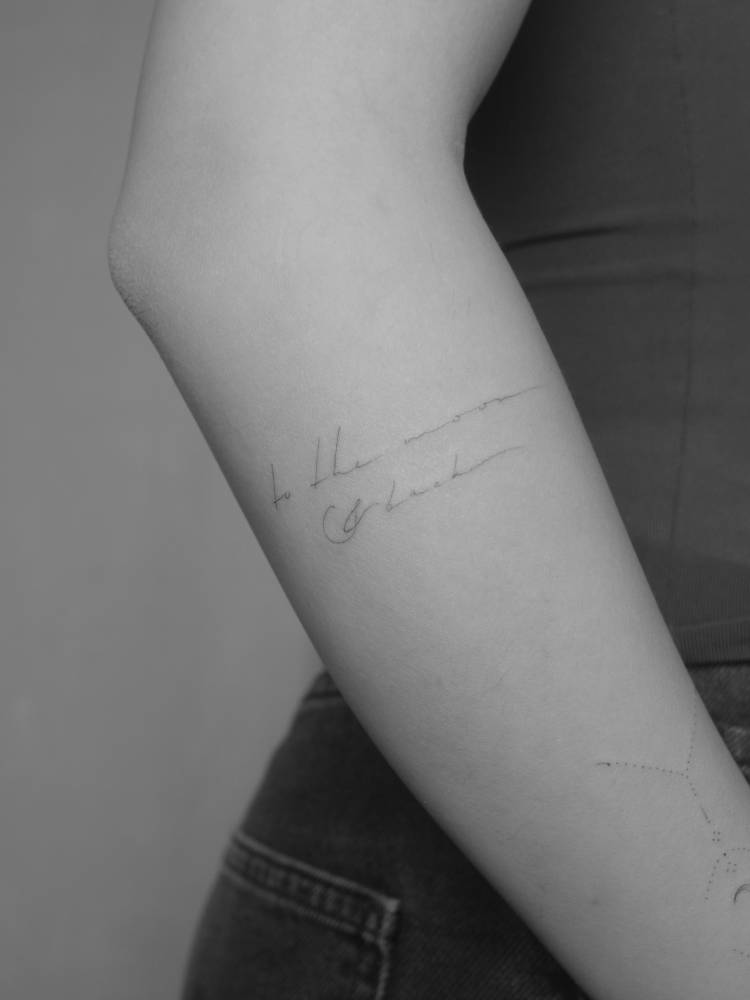 Handwritten font "to the moon and back" lettering tattoo.
