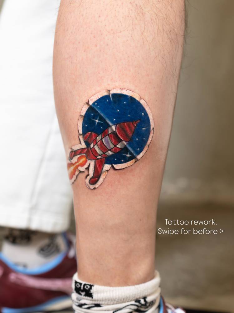 Tintin rocket sticker tattooed on the shin, cartoon style.