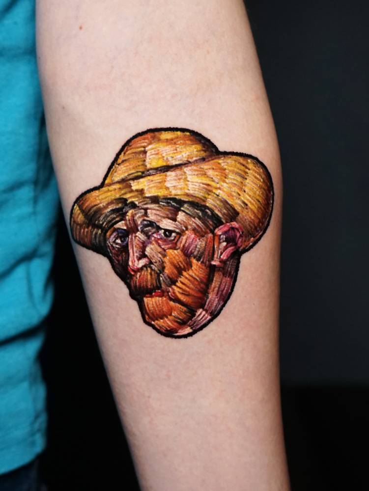 Embroidery style Van Gogh portrait tattoo located on the inner forearm.