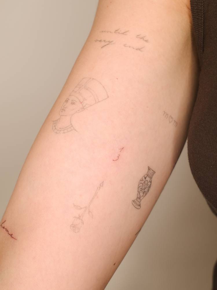 Tiny number "13" tattoo located on the inner forearm.