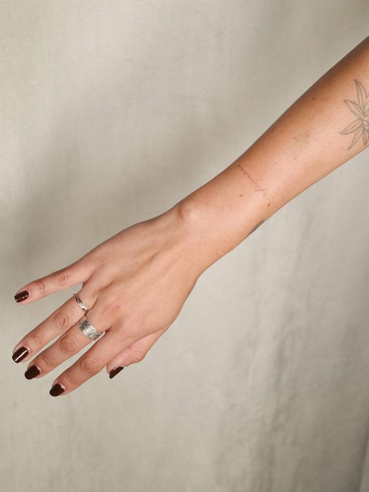 Handwritten font word "efemero" tattooed on the wrist.
