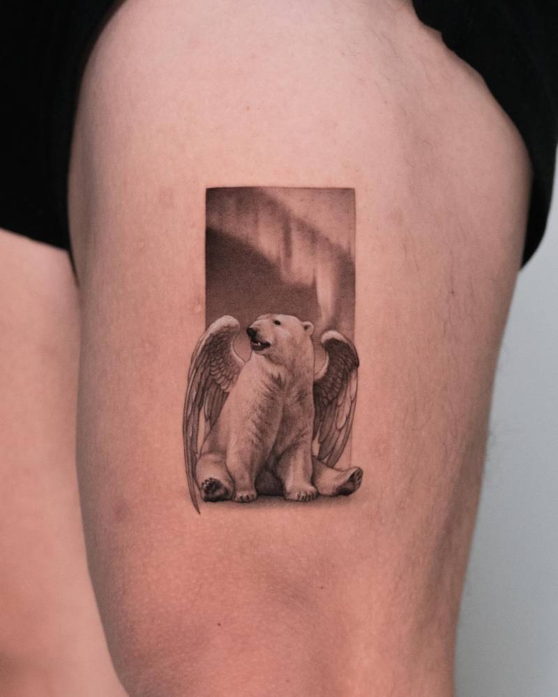 Micro-realistic style angel polar bear tattoo located on the thigh.