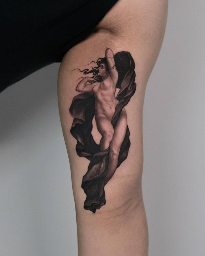 Classical style nude woman tattoo located on the inner arm.