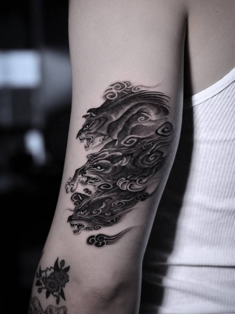 Wolf heads in oriental style located on the tricep.