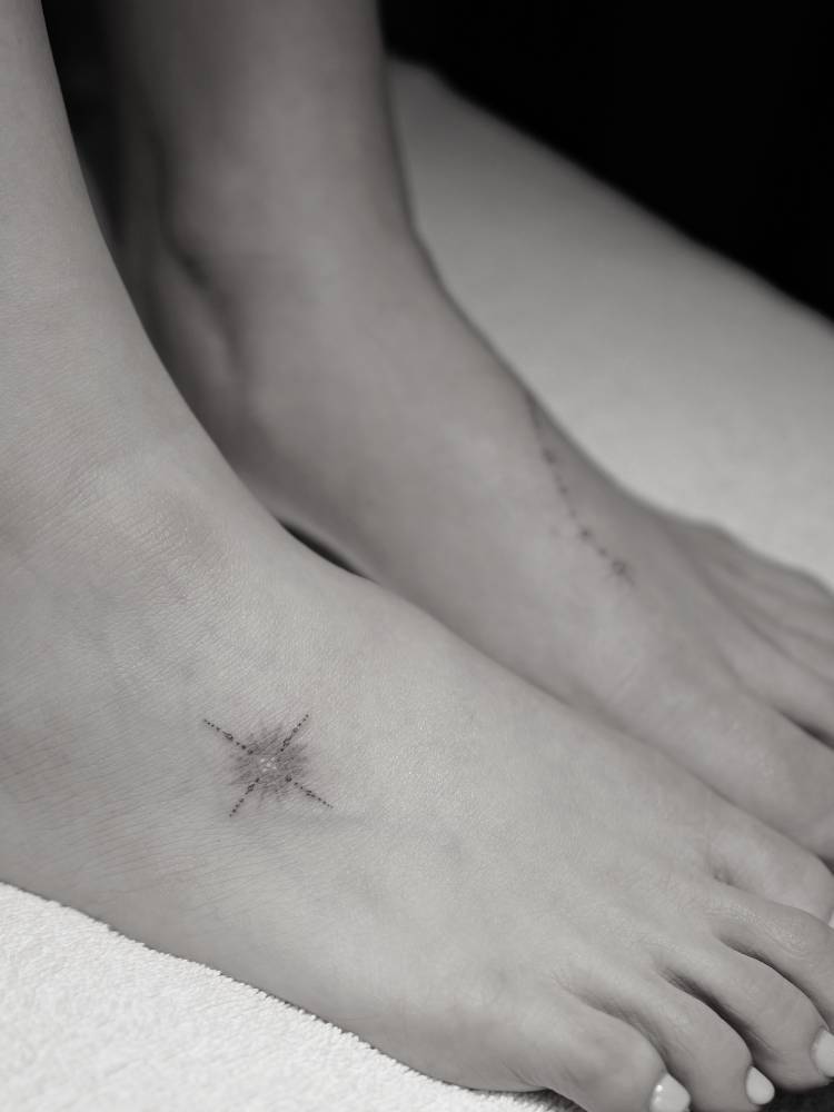 Single needle star ornament tattoo placed on the foot.
