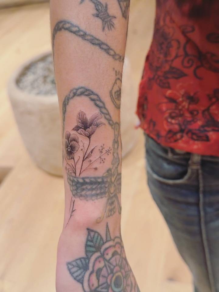 Flowers tattoo located on Mitra Yosri's wrist.