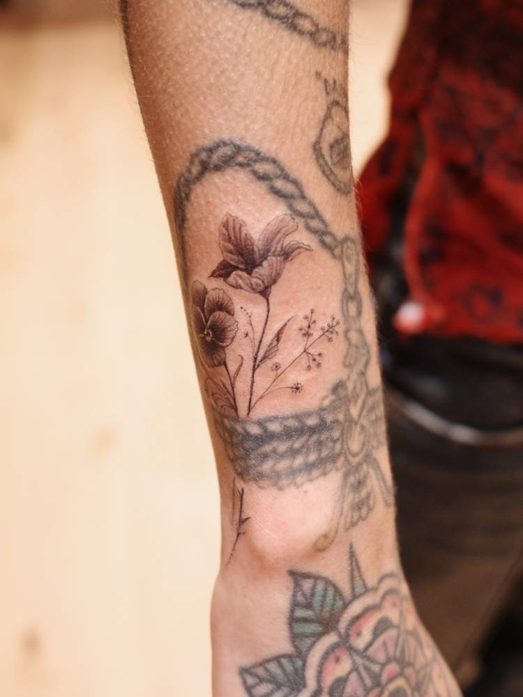 Flowers tattoo located on Mitra Yosri's wrist.