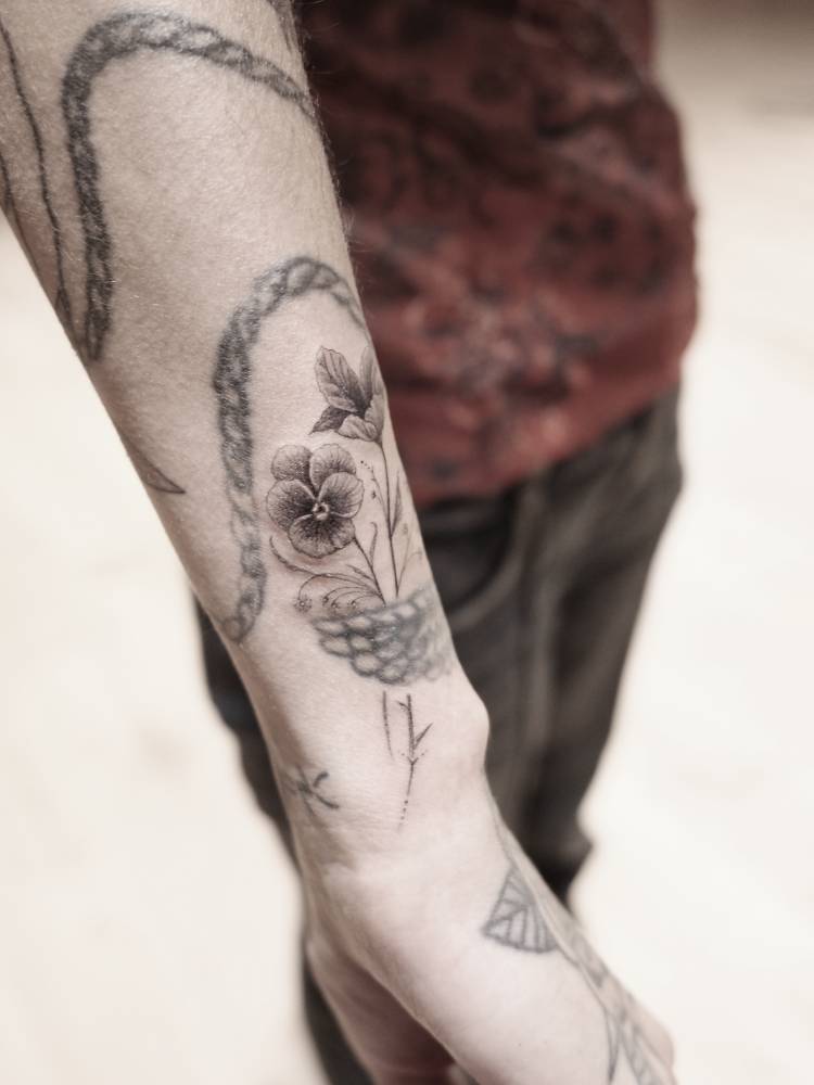 Flowers tattoo located on Mitra Yosri's wrist.