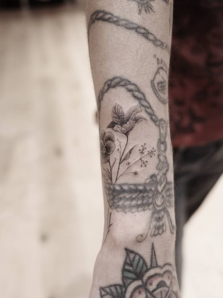 Flowers tattoo located on Mitra Yosri's wrist.