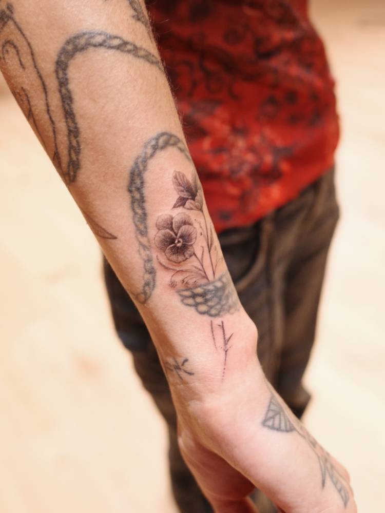 Flowers tattoo located on Mitra Yosri's wrist.