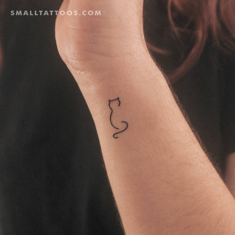 Minimalist little cat temporary tattoo located on the wrist.