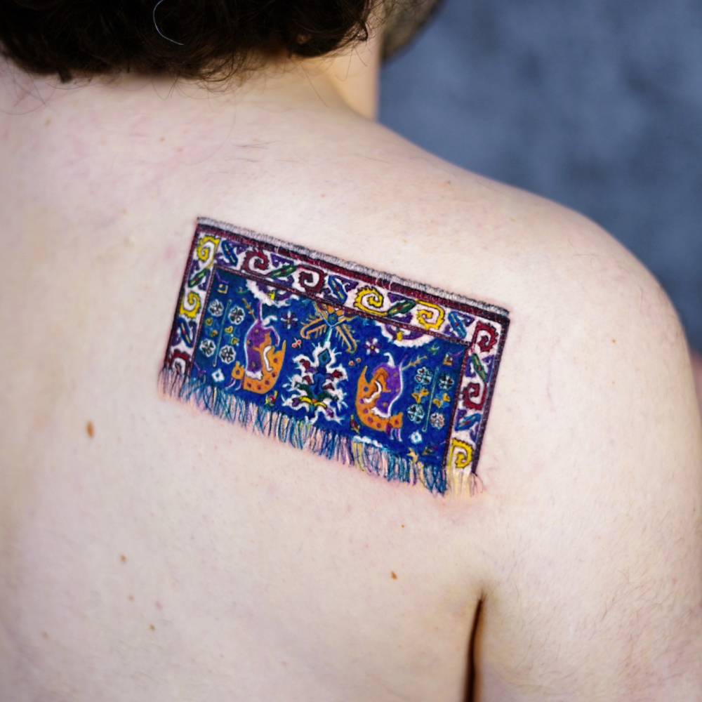 Armenian rug tattoo in micro-realistic style located on the shoulder blade.