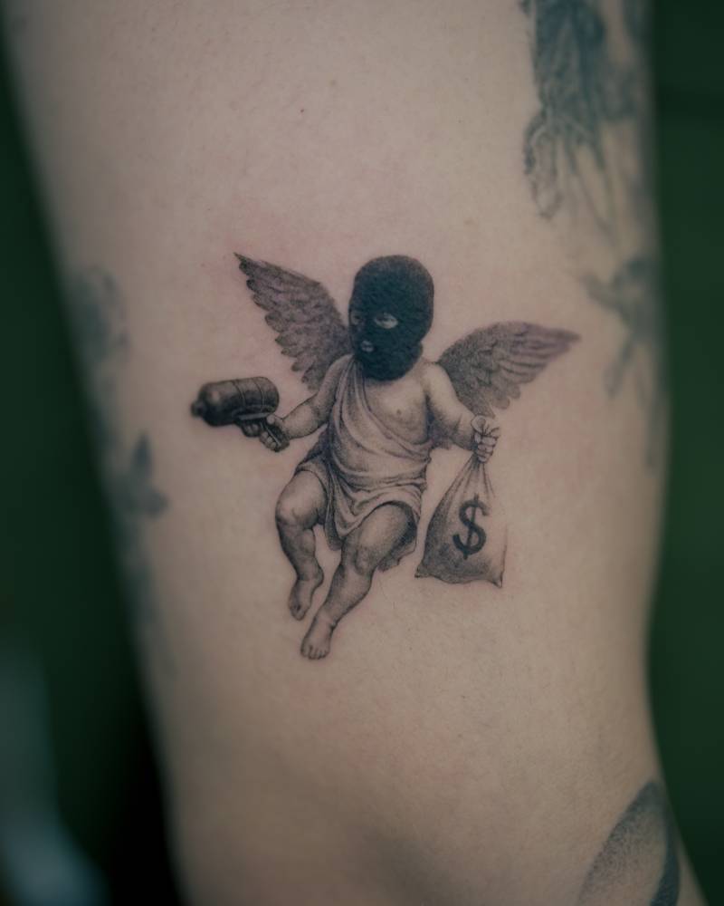 Micro-realistic style thug cherub tattooed on the upper arm.