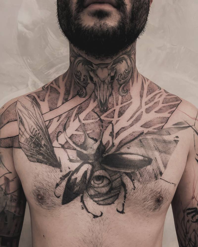 Healed beetle and fresh ram skull tattoo located on the chest and neck.