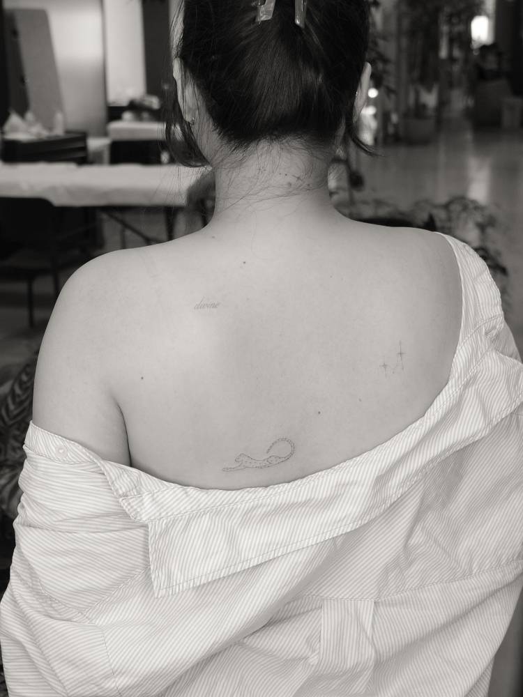 Leopard tattoo in fine line style located on the shoulder blade.