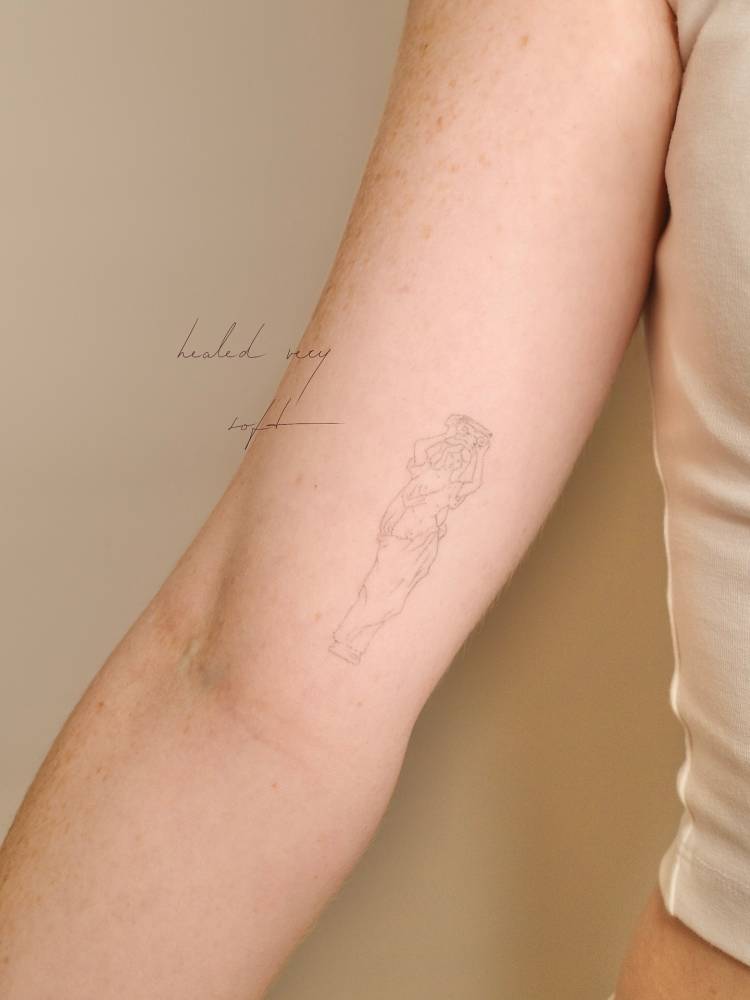 Healed greek sculpture tattoo done in fine line style.