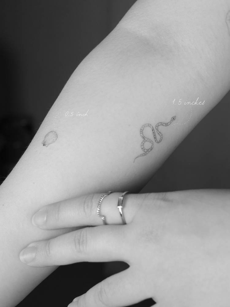 FIne line style snake tattoo located on the inner forearm.