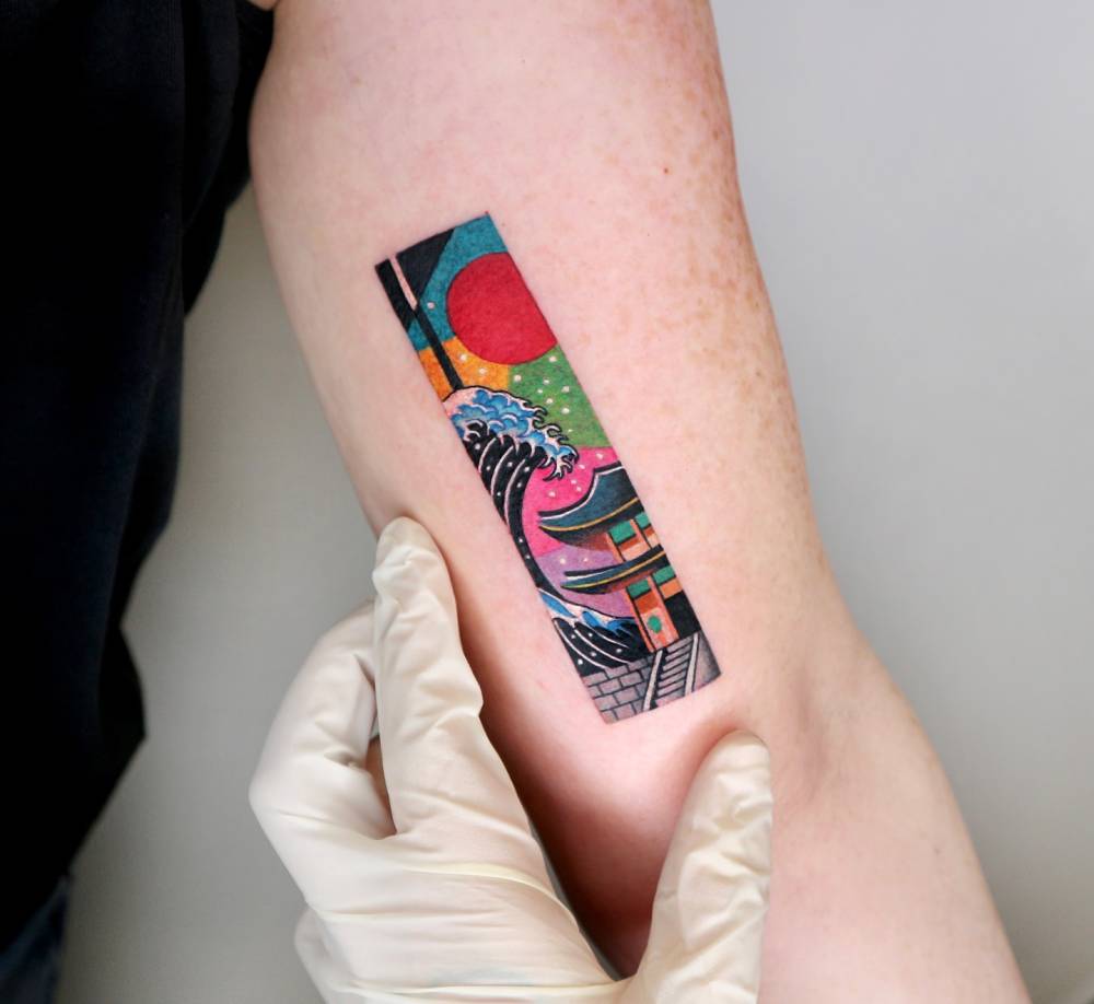 Wave and pagoda tattoo located on the inner arm, illustrative style.