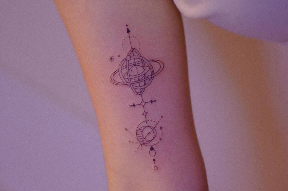 Fine line style time-turner tattoo located on the inner arm.
