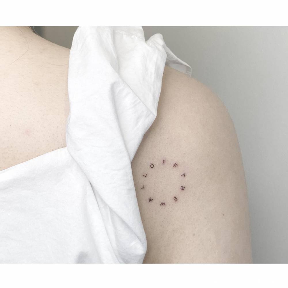 "Off the wall" lettering tattoo in circle located on the shoulder.