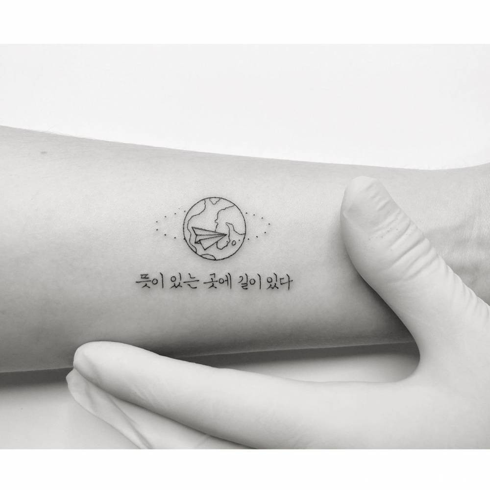 Around the world and Korean lettering tattooed on the wrist.