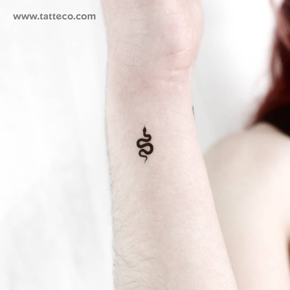 Tiny black snake temporary tattoo located on the wrist.
