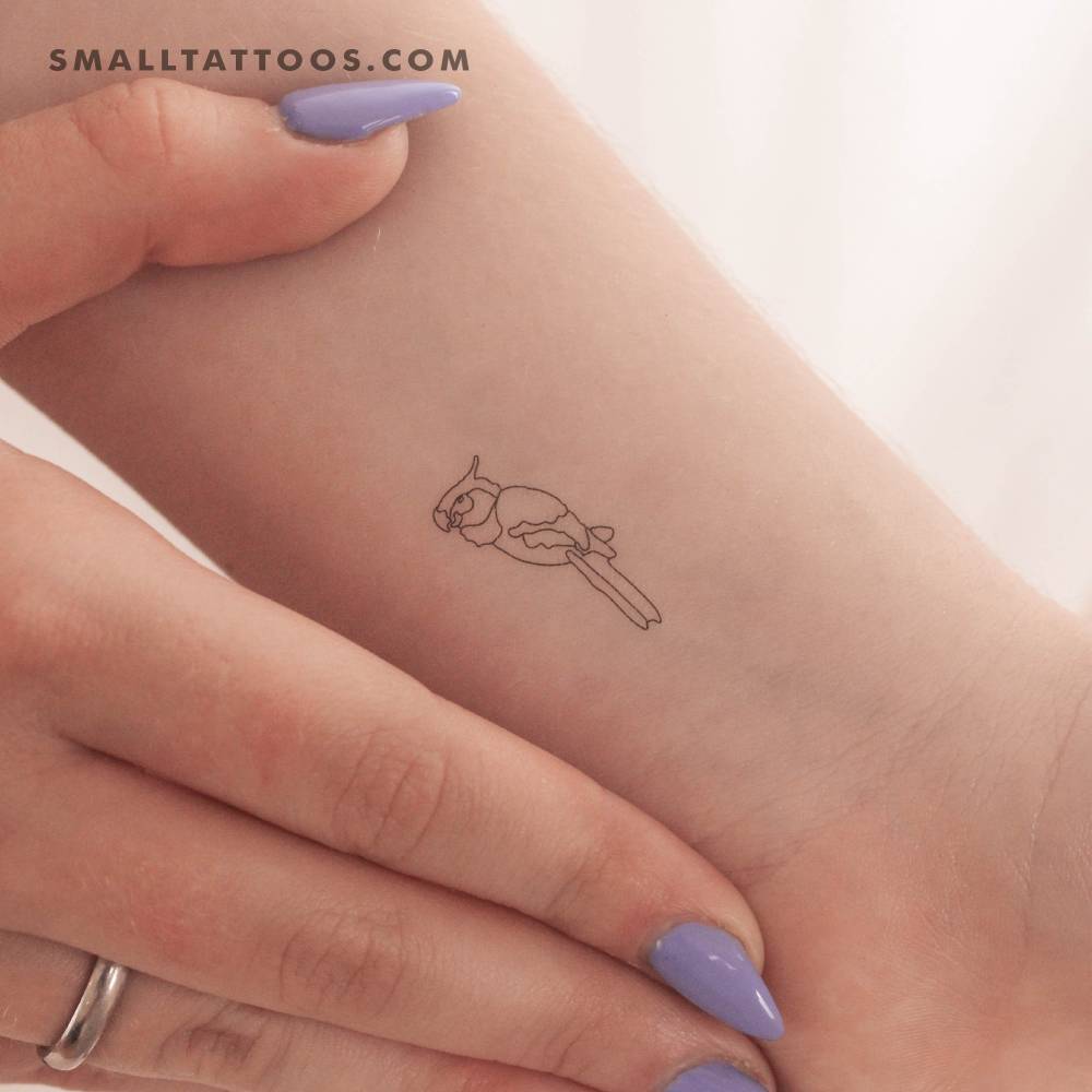 Fine line style parrot temporary tattoo located on the wrist.