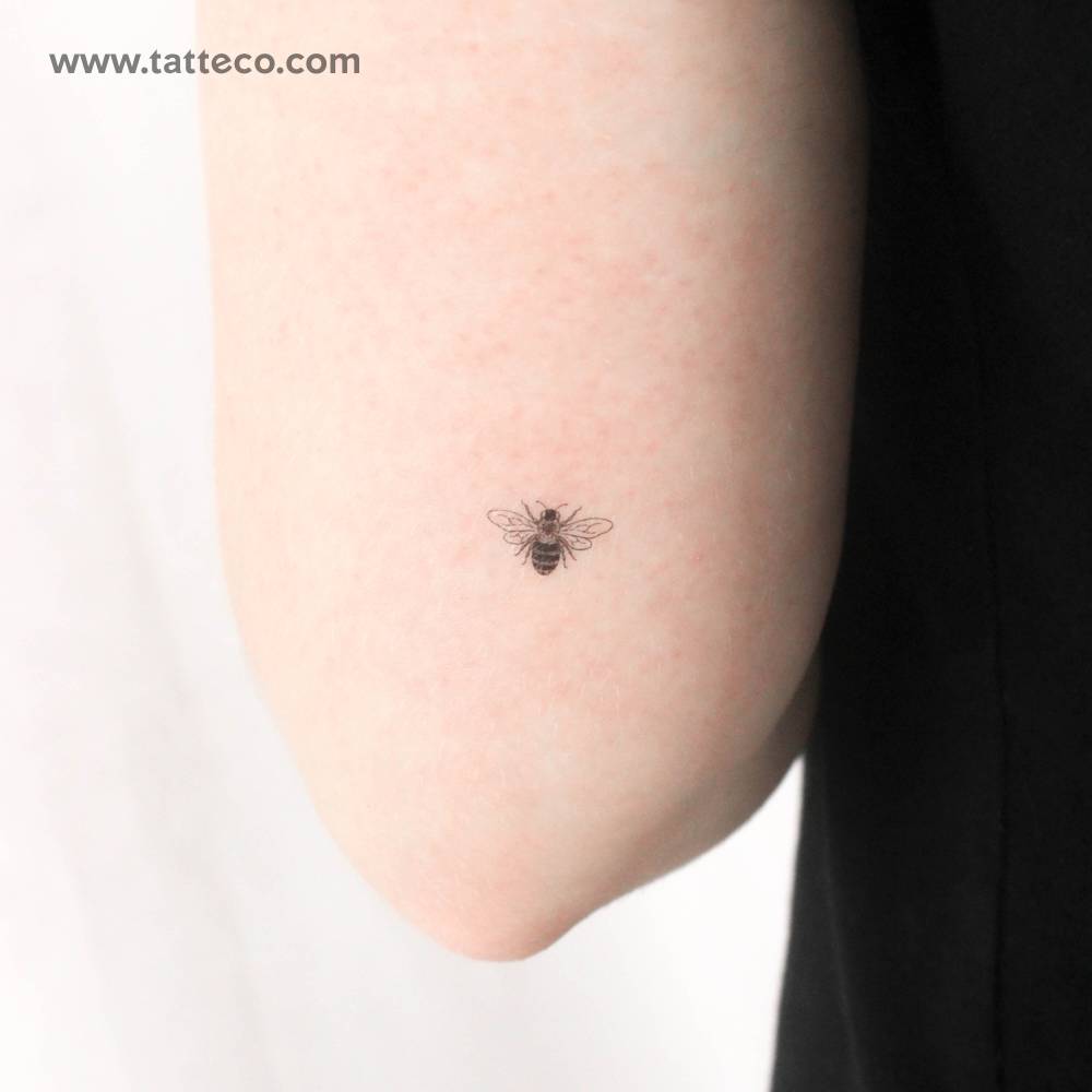 Little hand-drawn bee temporary tattoo located on the tricep.