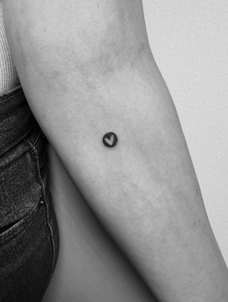 Minimalist little heart tattoo placed on the inner forearm.