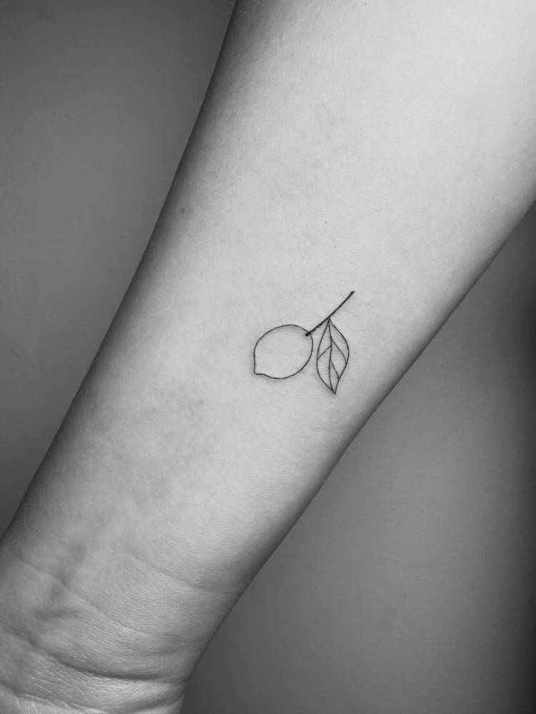Tiny lemon tattoo done on the wrist, minimalist style.