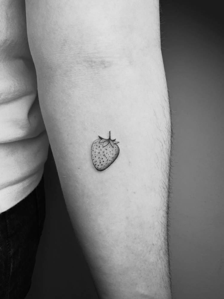 Strawberry tattoo located on the inner forearm, done in illustrative style.