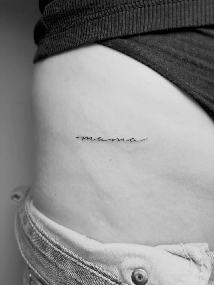 "Mama" lettering tattoo located on the waist.