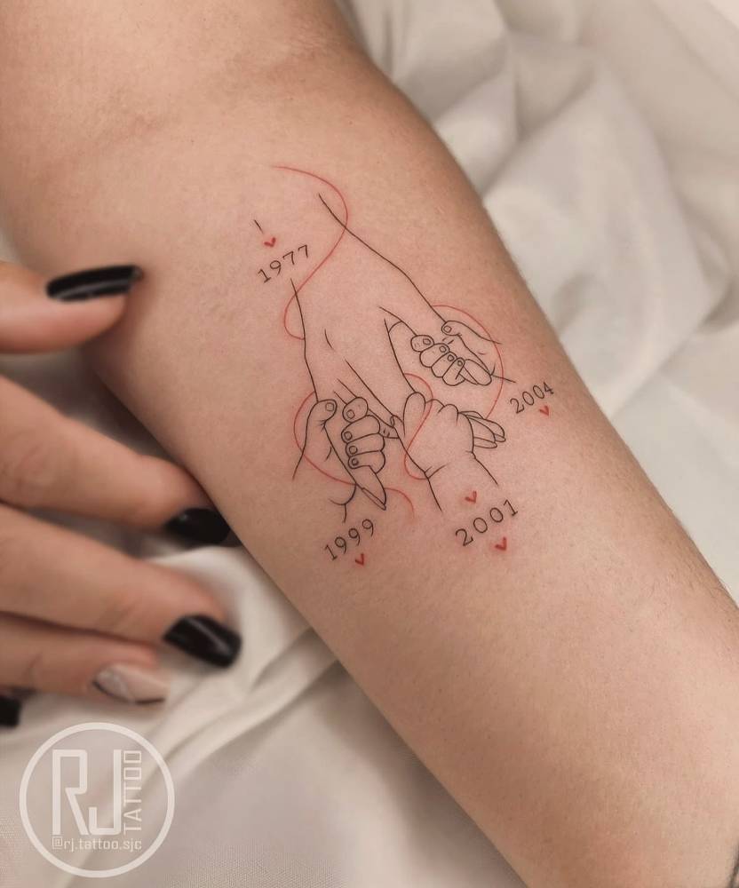 Fine line style baby hands holding mum's hand tattooed on the inner forearm.