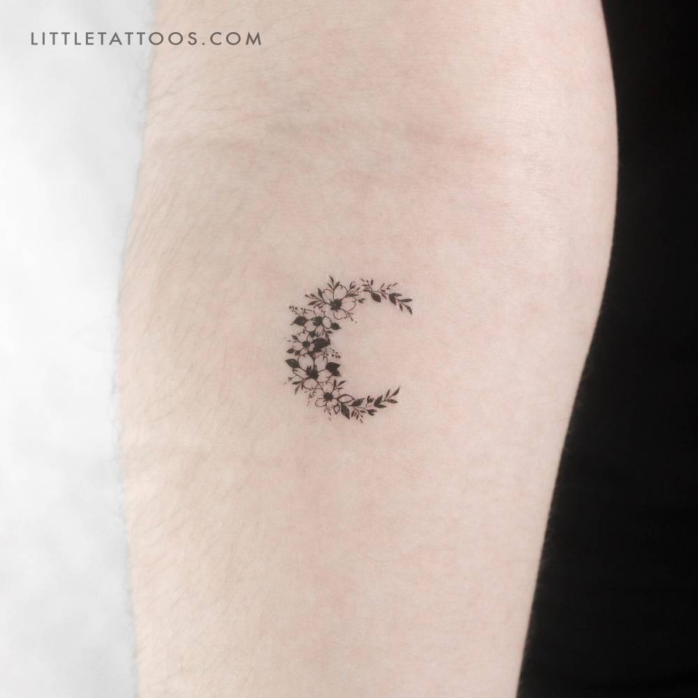 Little floral crescent moon temporary tattoo located on the inner forearm.