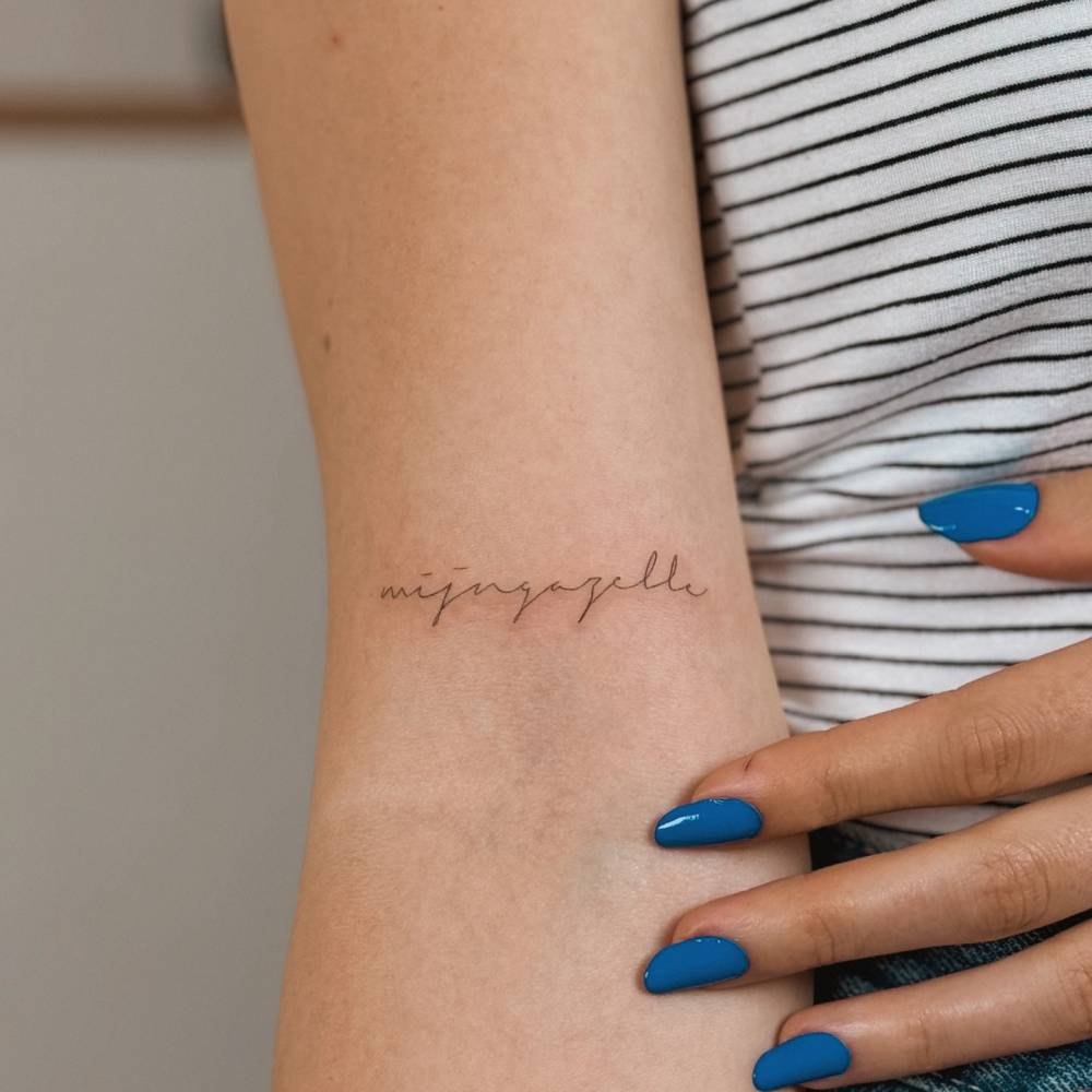 Handwritten lettering tattoo located on the bicep.