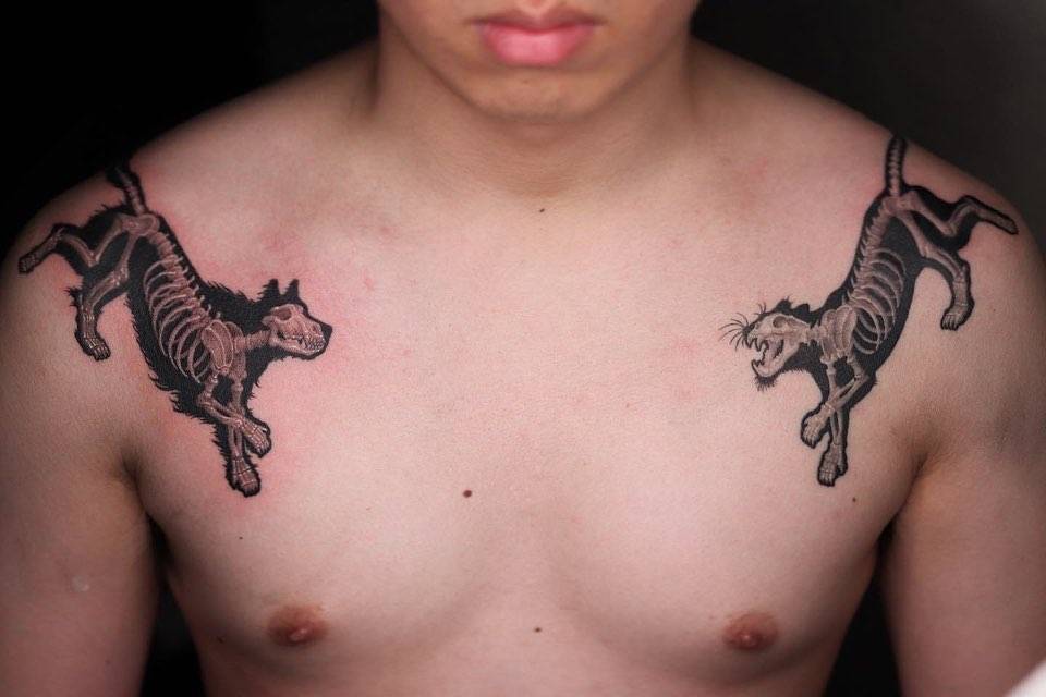 Individual matching wolves x-ray tattooed on the shoulders.