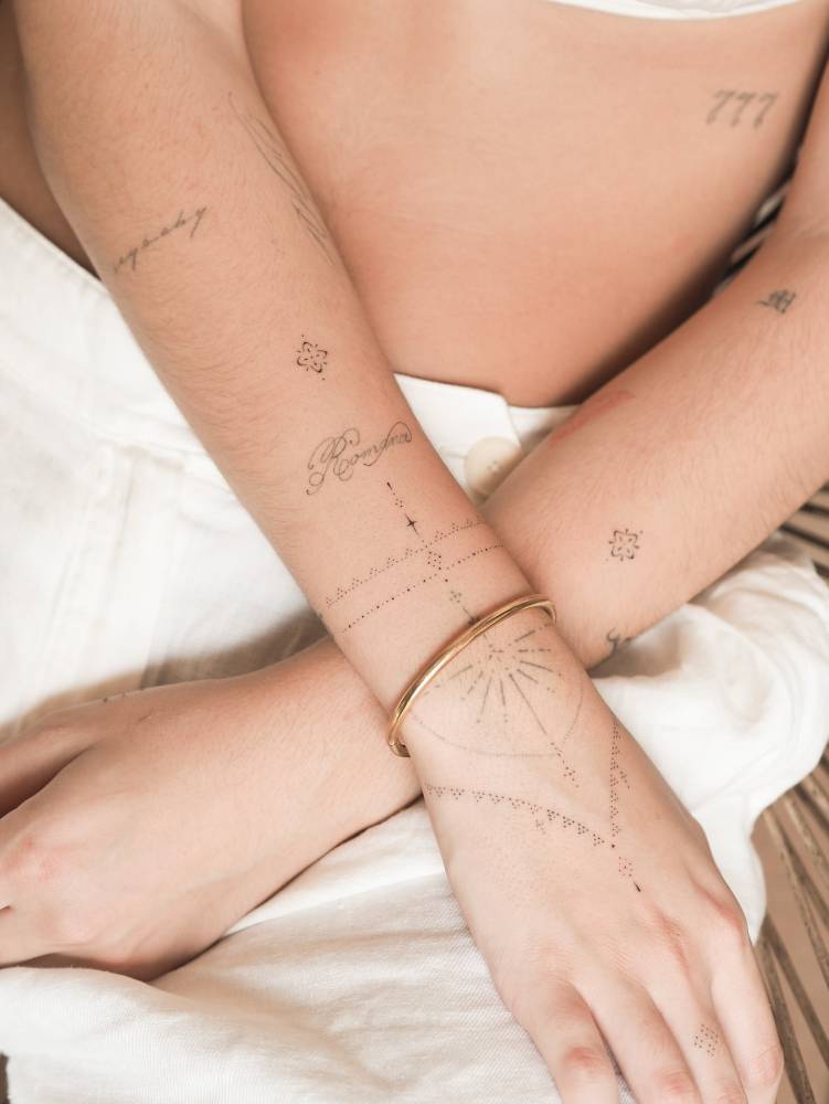 Fine line style ornamental design tattooed on the wrist and hand.