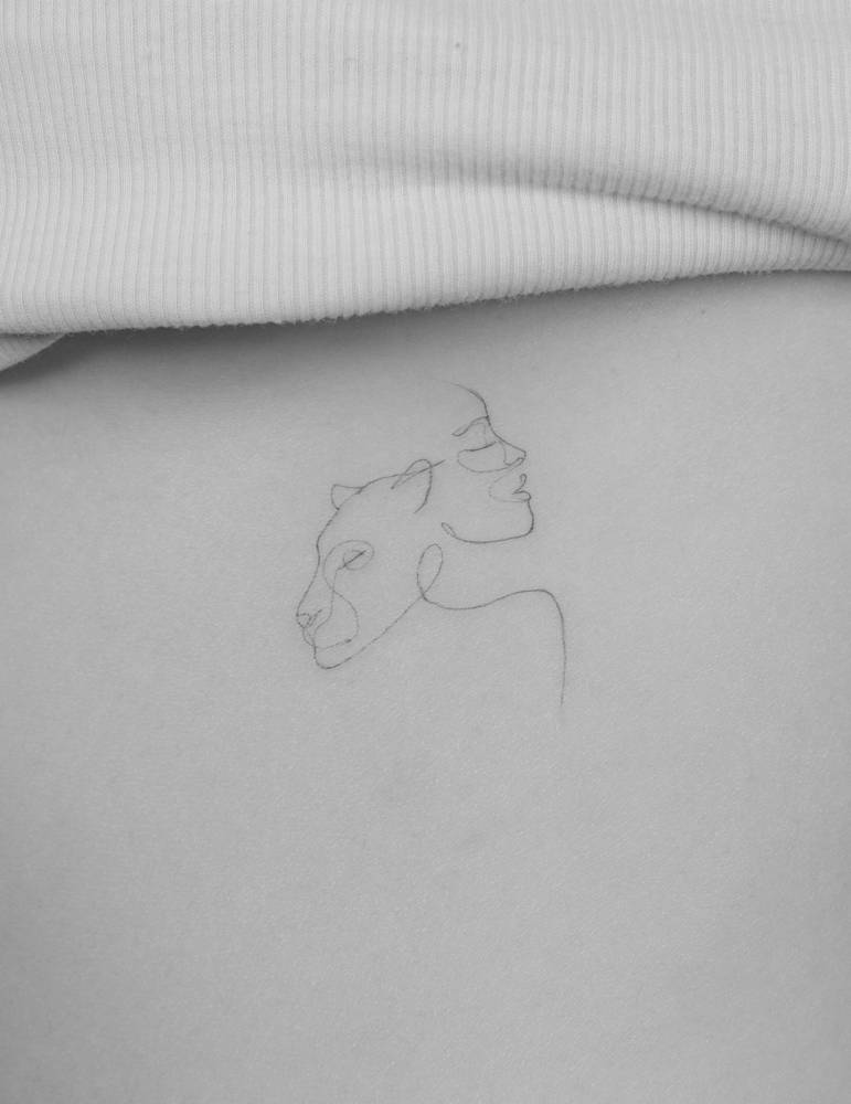 Lioness and woman portrait tattooed on the rib, fine line style.